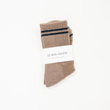 Striped brown socks with a white label saying le bon shoppe.