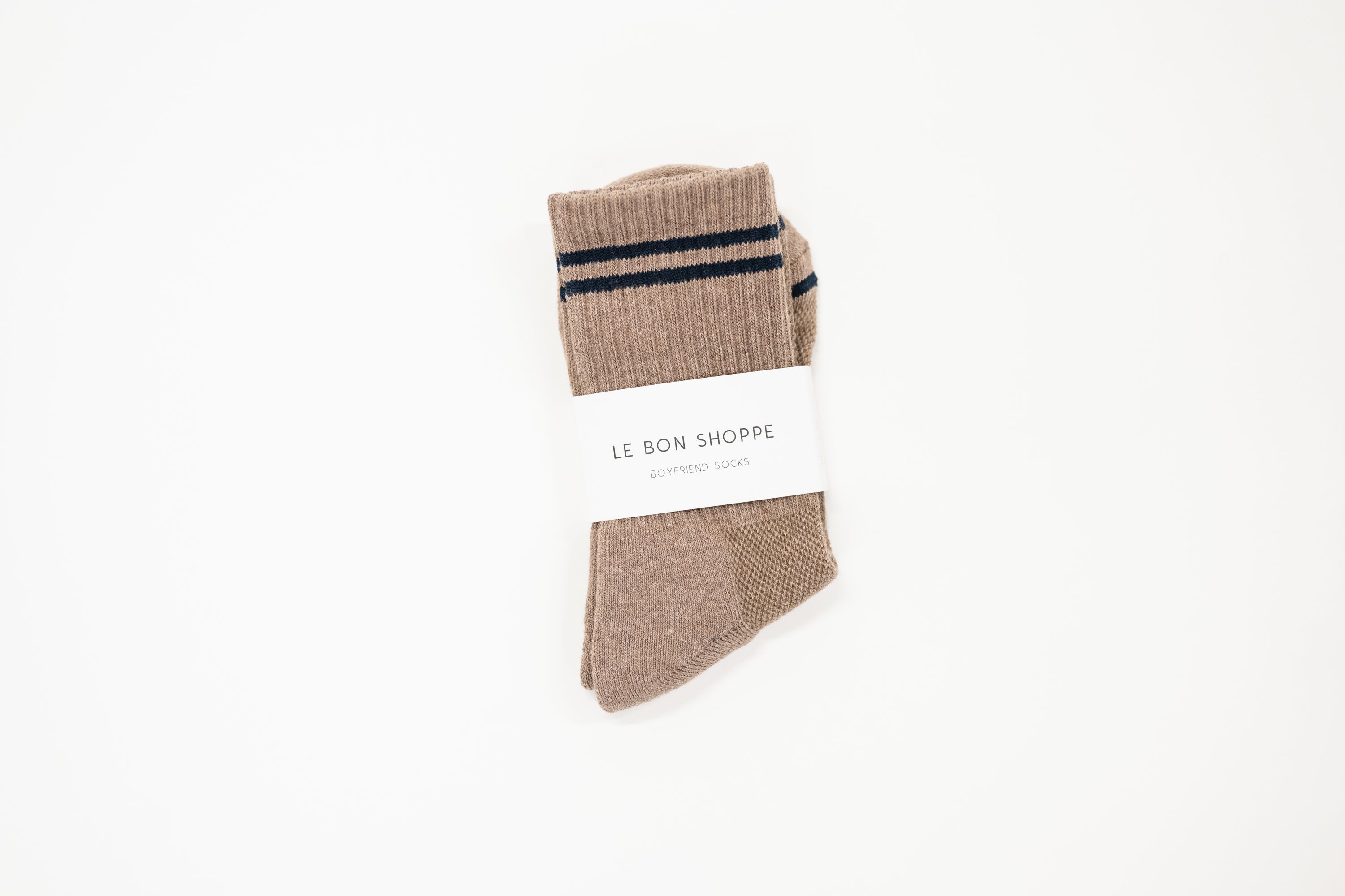 Striped brown socks with a white label saying le bon shoppe.