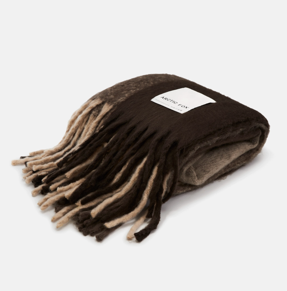 A folded knit scarf with fringe, featuring a color-blocked design in dark brown, medium brown, and beige. A white rectangular label with the brand name 'ANTHONY' is stitched onto the side.
