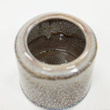 Ceramic pot with textured brown white surface on a white background