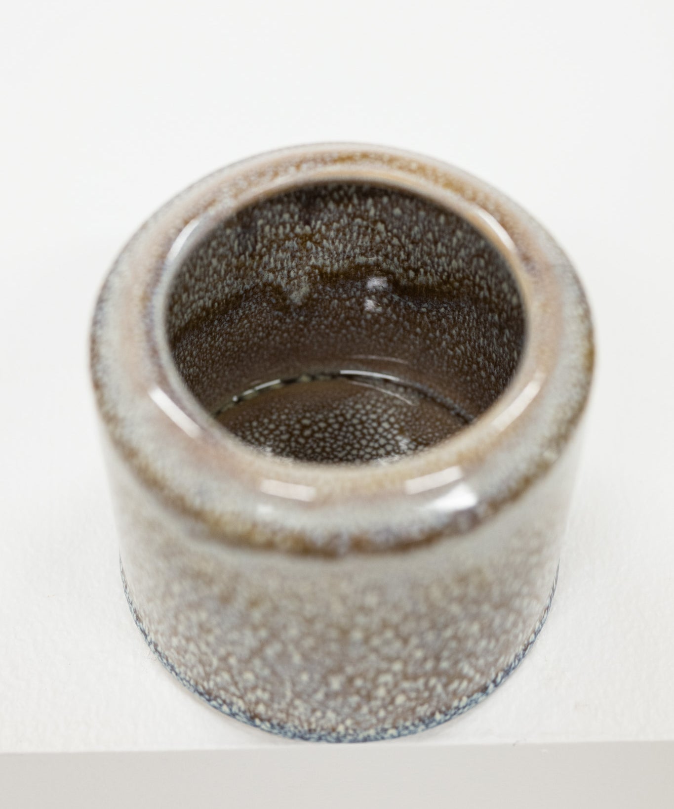 Ceramic pot with textured brown white surface on a white background