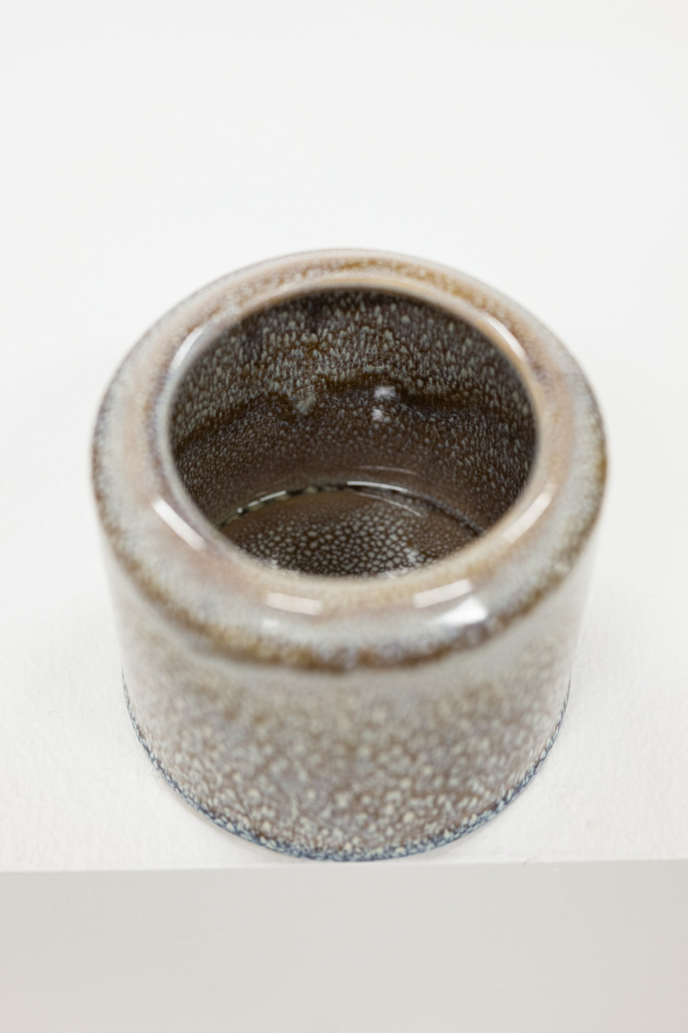 Ceramic pot with textured brown white surface on a white background