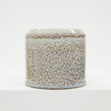 Speckled ceramic jar on a white background