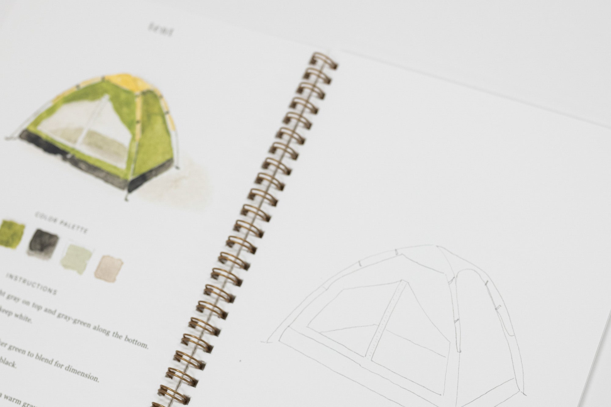An open spiral notebook showing a tent color palette page with a green and yellow tent illustration, small color swatches, and a line drawing of the tent on white pages.