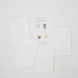 A set of white printable or watercolor birthday cards with simple line drawings and small illustrated accents, arranged on a light gray background. One card shows balloons, another a gift, another a cupcake, and another a party hat.