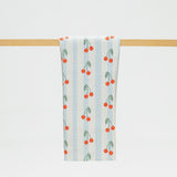 Towel with cherry pattern hanging on a wooden rack against a white background