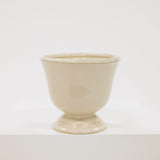Beige ceramic cup on a white background