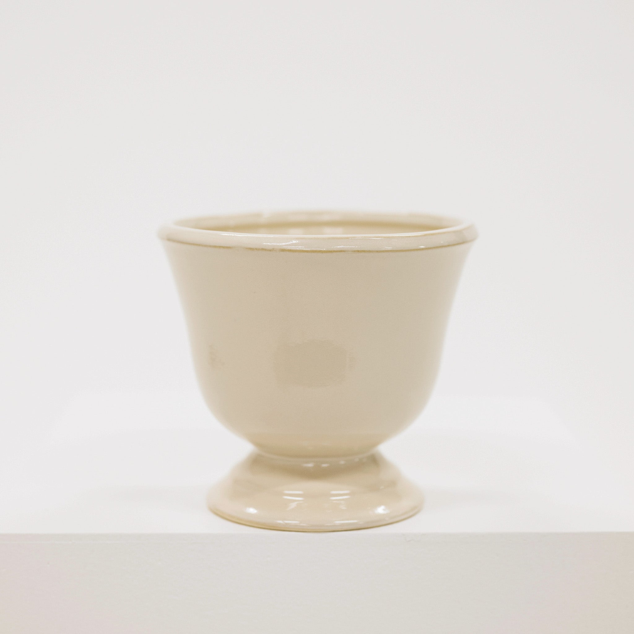 Beige ceramic cup on a white background