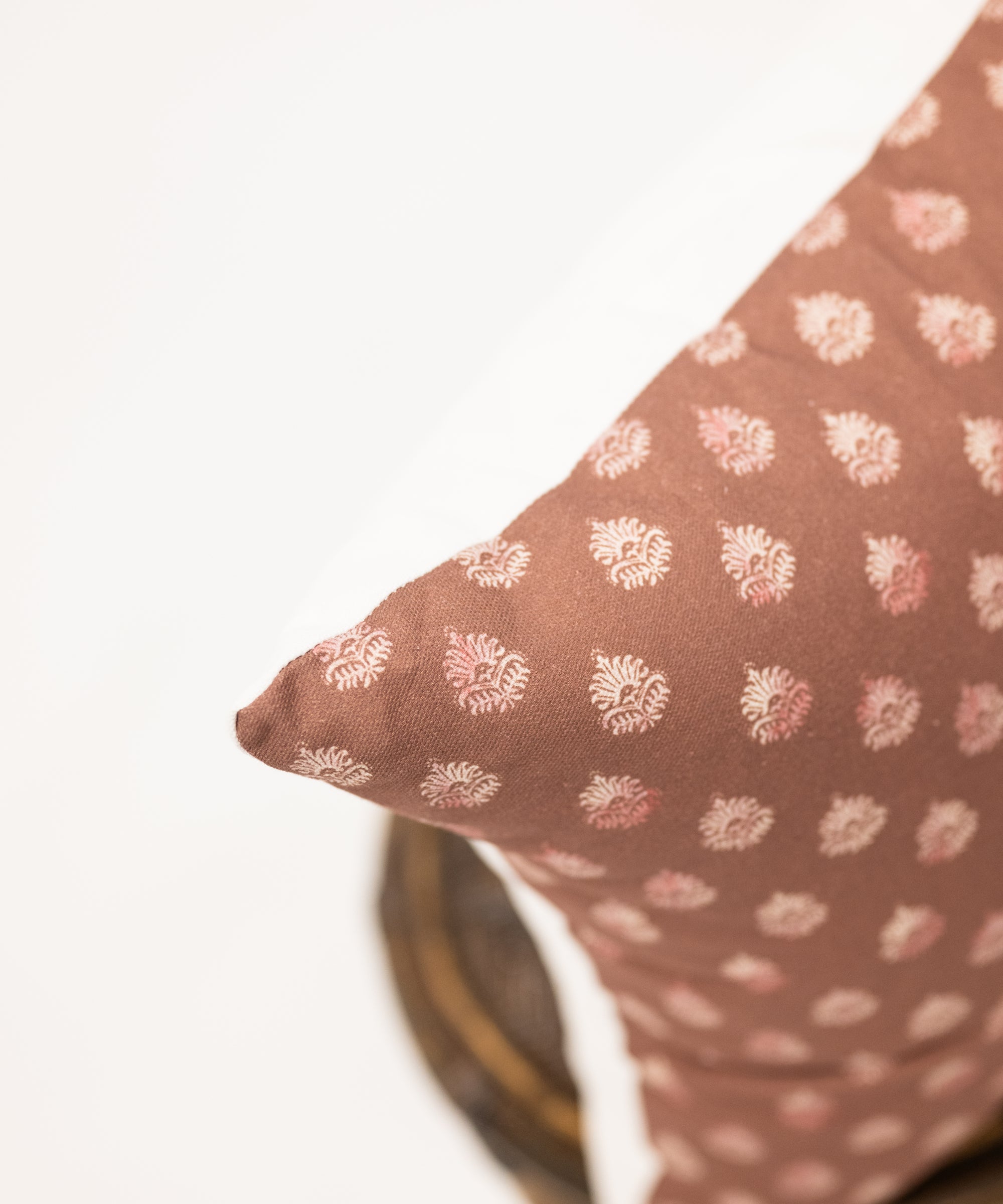 clay colored square pillow with block print pattern 