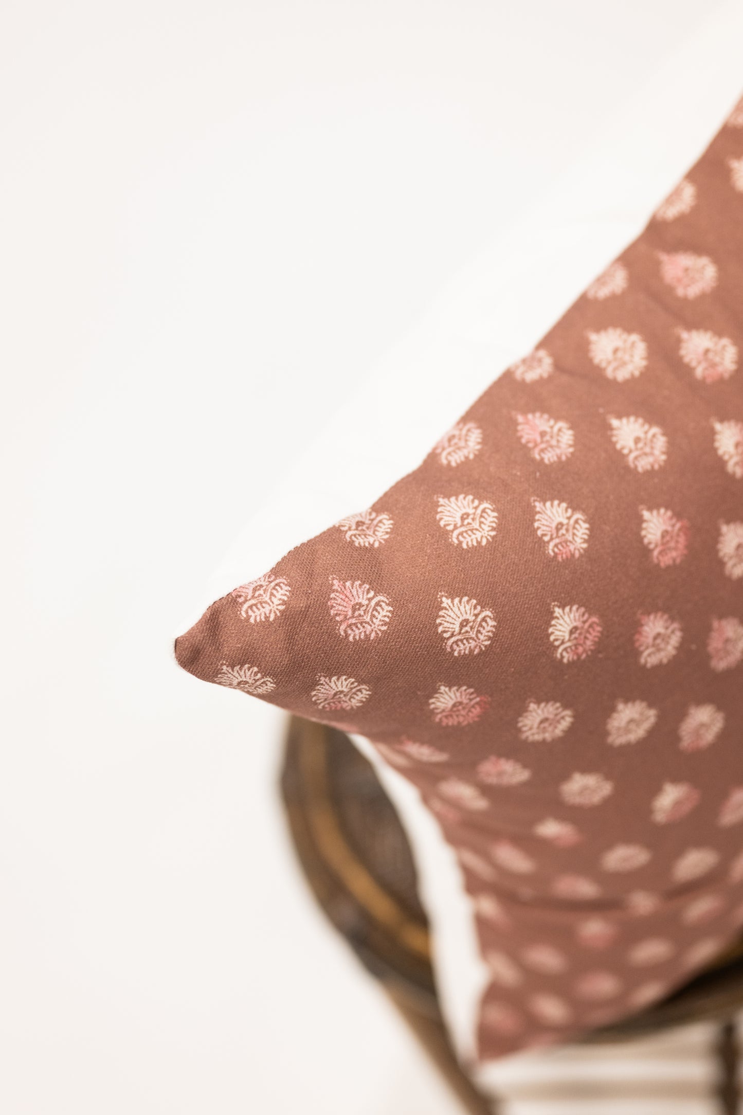 clay colored square pillow with block print pattern 