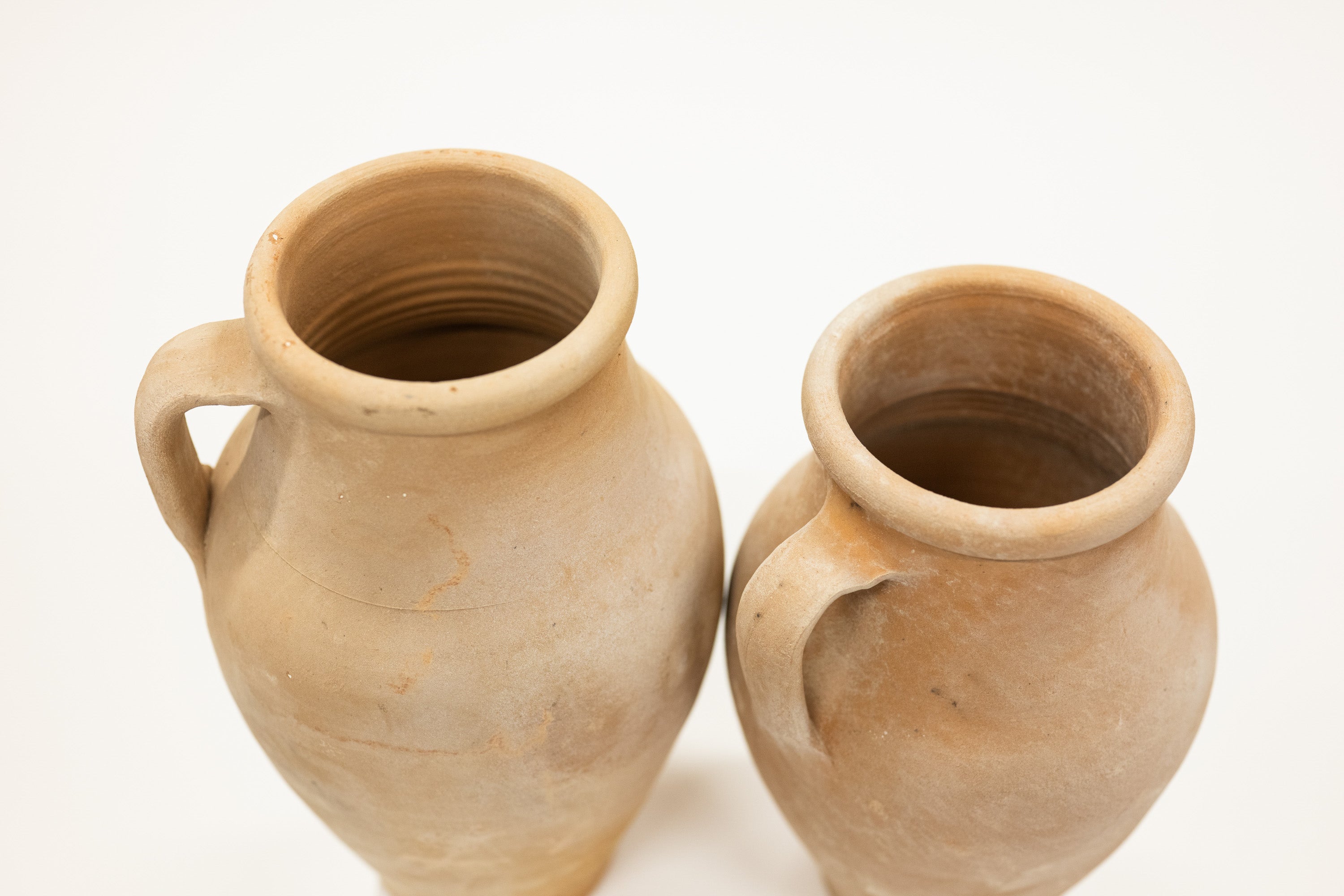 Two terracotta pots on a white background