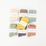 A collection of socks in various colors, neatly arranged on a white surface, each with a label indicating the size range of 6-10.