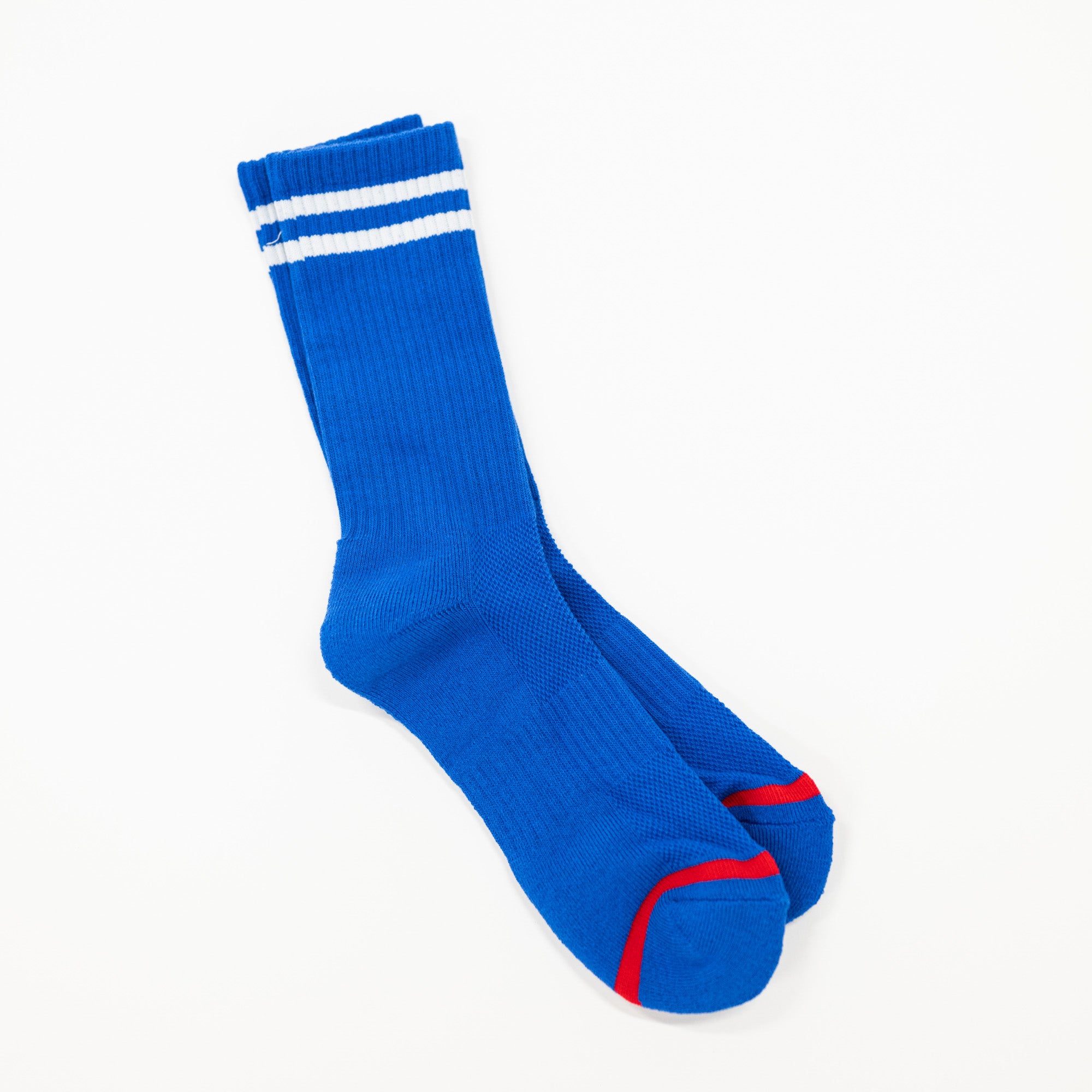 A pair of royal blue crew socks with two white stripes near the cuff and red accents on the toes, displayed on a clean white background.