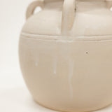 Beige ceramic jar with handles on a white background