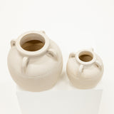 Two ceramic vases on a white surface with a white background