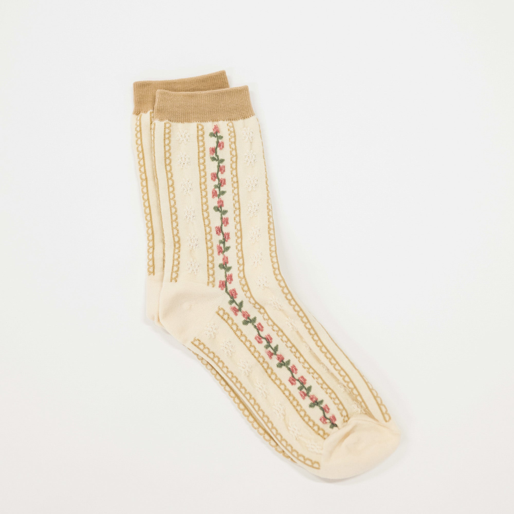 Cream colored crew socks featuring scalloped stripes and a stripe of flowers.