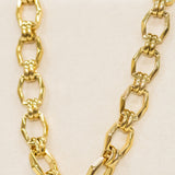 Gold chain necklace on a beige background