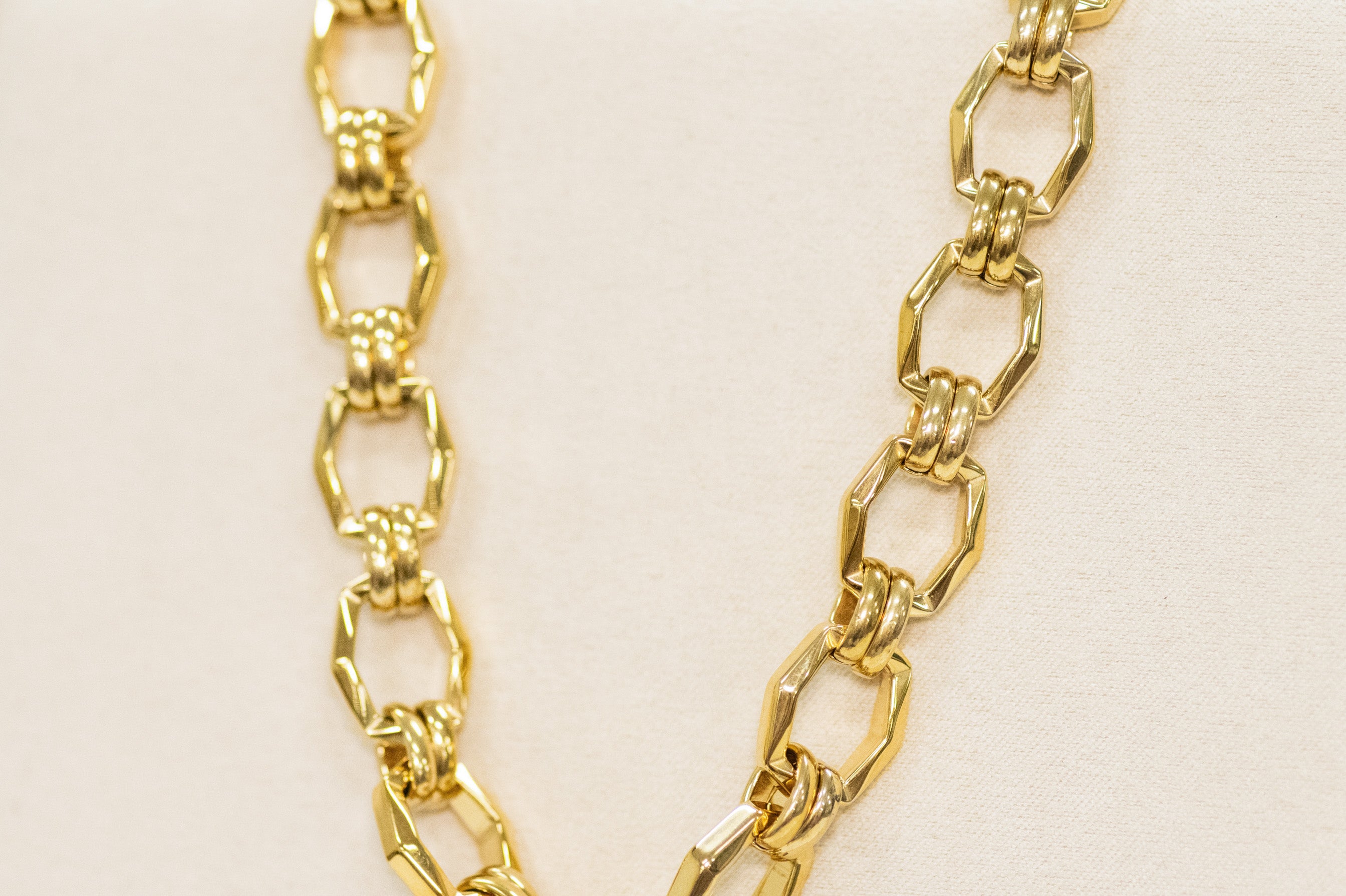 Gold chain necklace on a beige background