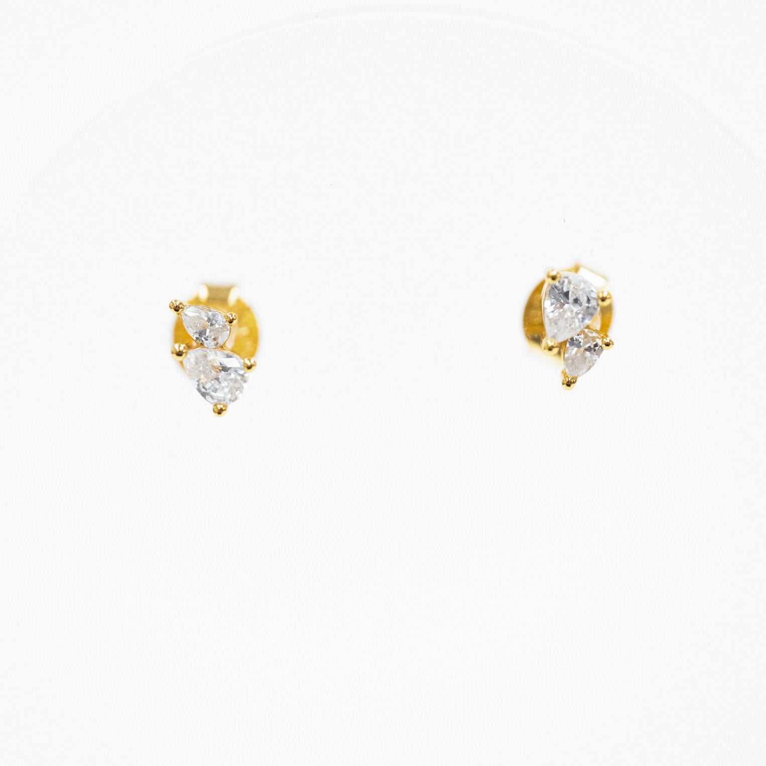 A pair of gold stud earrings with three marquise-cut clear gemstones in a prong setting, displayed on a plain white background.