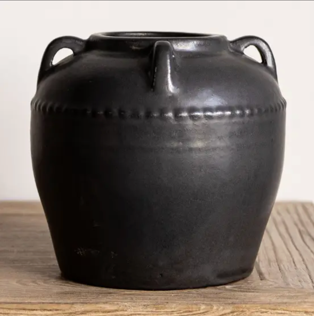 a dark grey vase with matte finish, featuring four handles