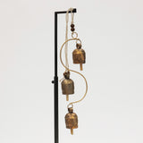 Decorative hanging with brass bell chime on a white background