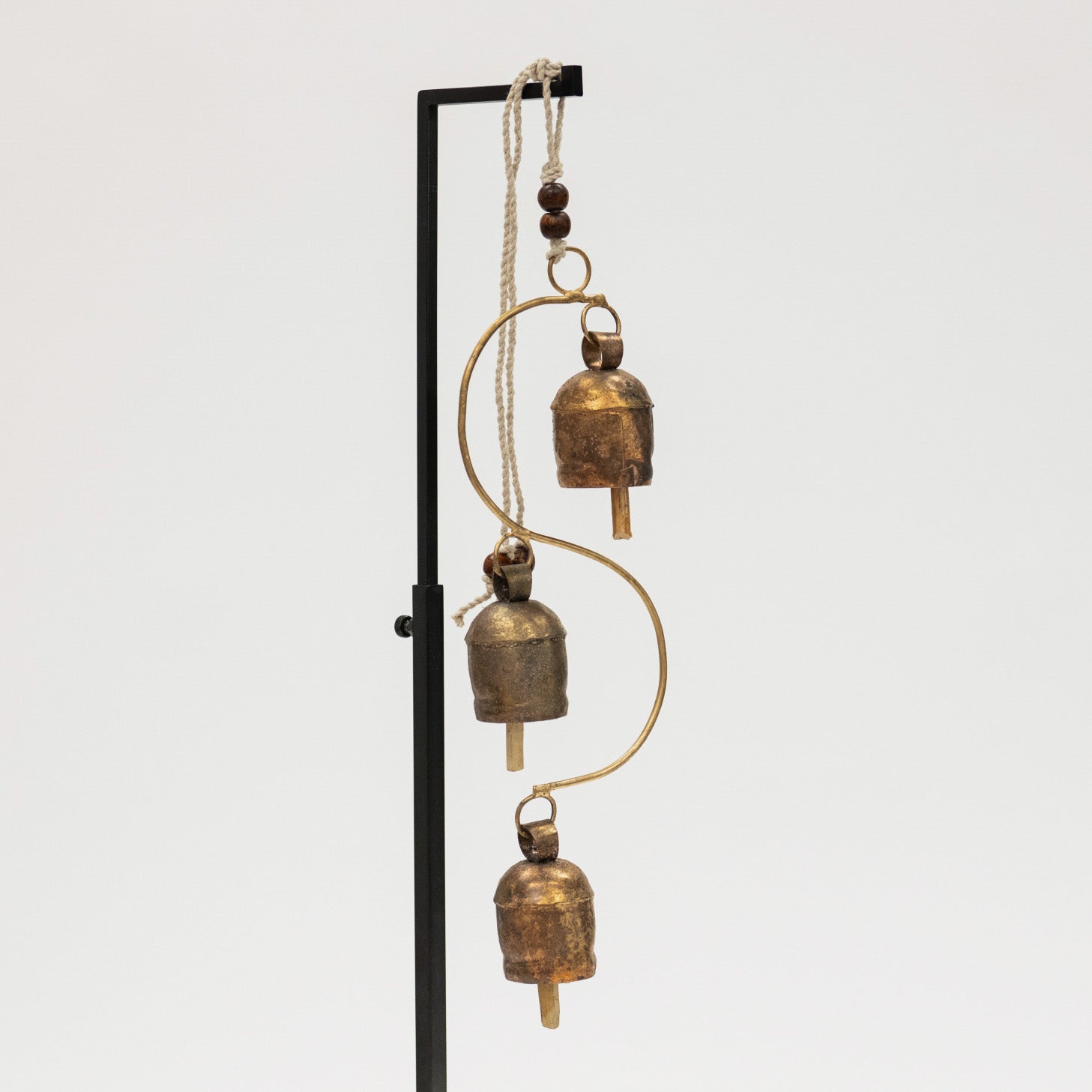 Decorative hanging with brass bell chime on a white background