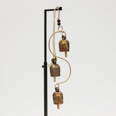Decorative hanging with brass bell chime on a white background