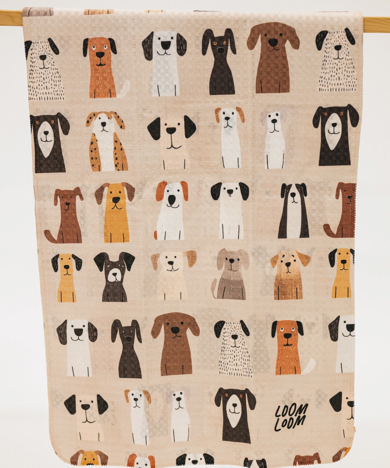 Beige towel with illustrations of dogs and 'LOOM LOOM' branding.