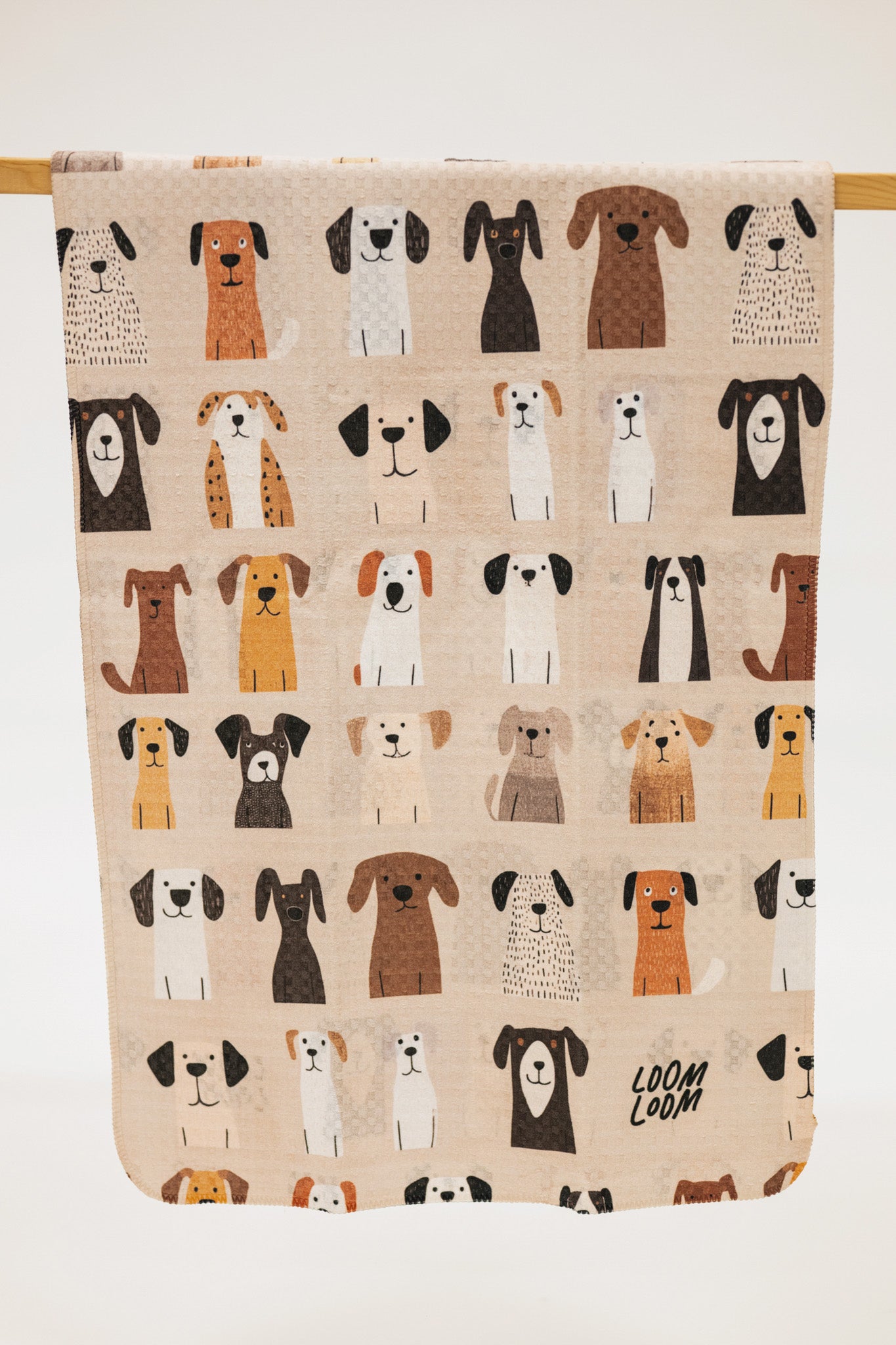 Beige towel with illustrations of dogs and 'LOOM LOOM' branding.