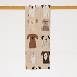 Towel with dog pattern hanging on a wooden rod against a white background