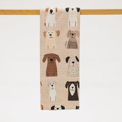Towel with dog pattern hanging on a wooden rod against a white background