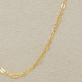 Gold chain necklace on a beige background