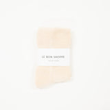white cloud socks on a white surface, each with a label indicating the brand le bon shoppe