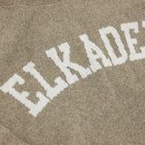 Text 'ELKADER' printed on a brown fabric background