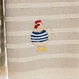 taupe and cream striped turkish cotton towel with fringe and embroidered chicken wearing a blue sweater.