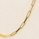 Gold chain necklace on a beige background