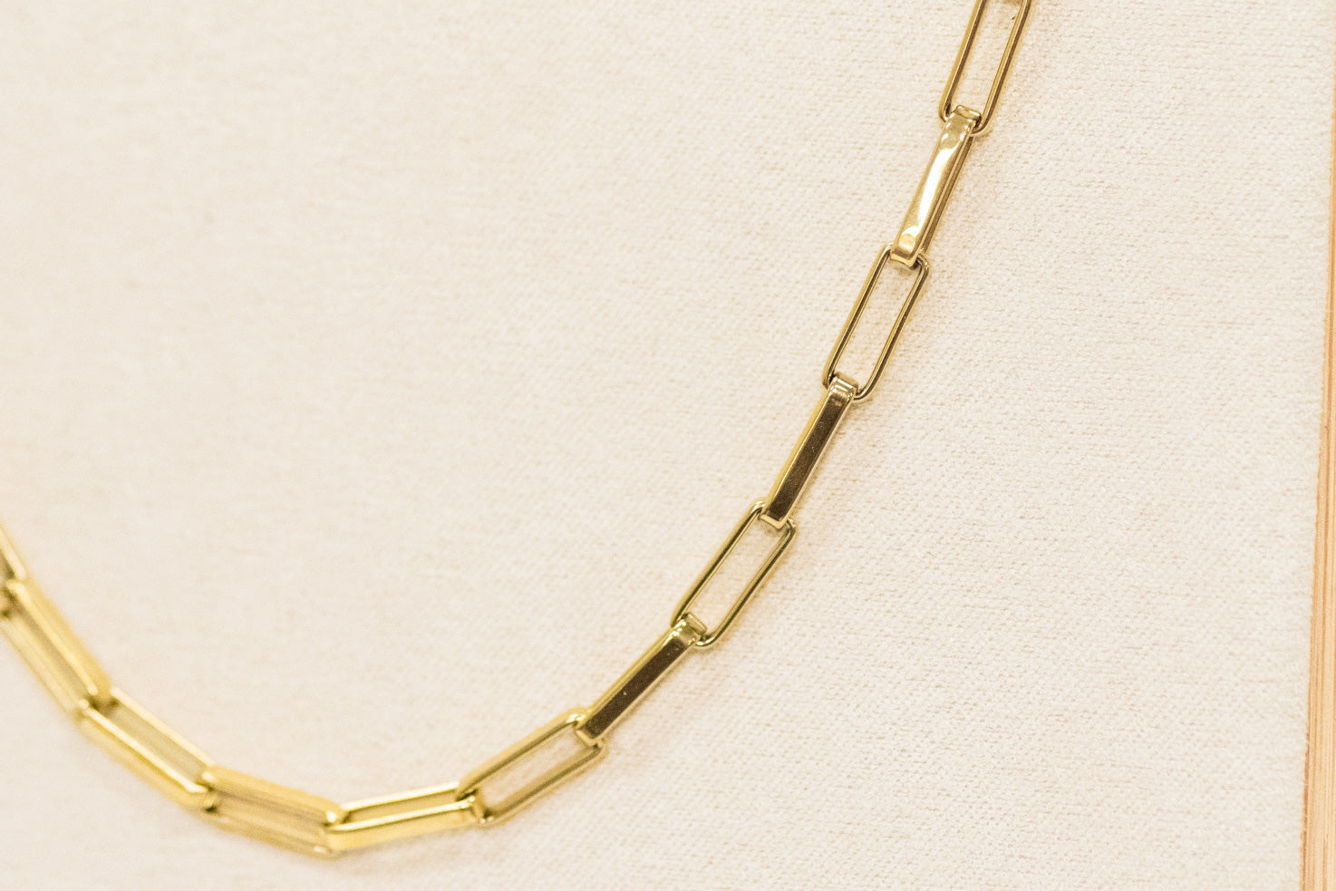 Gold chain necklace on a beige background