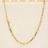 Gold chain necklace on a beige background