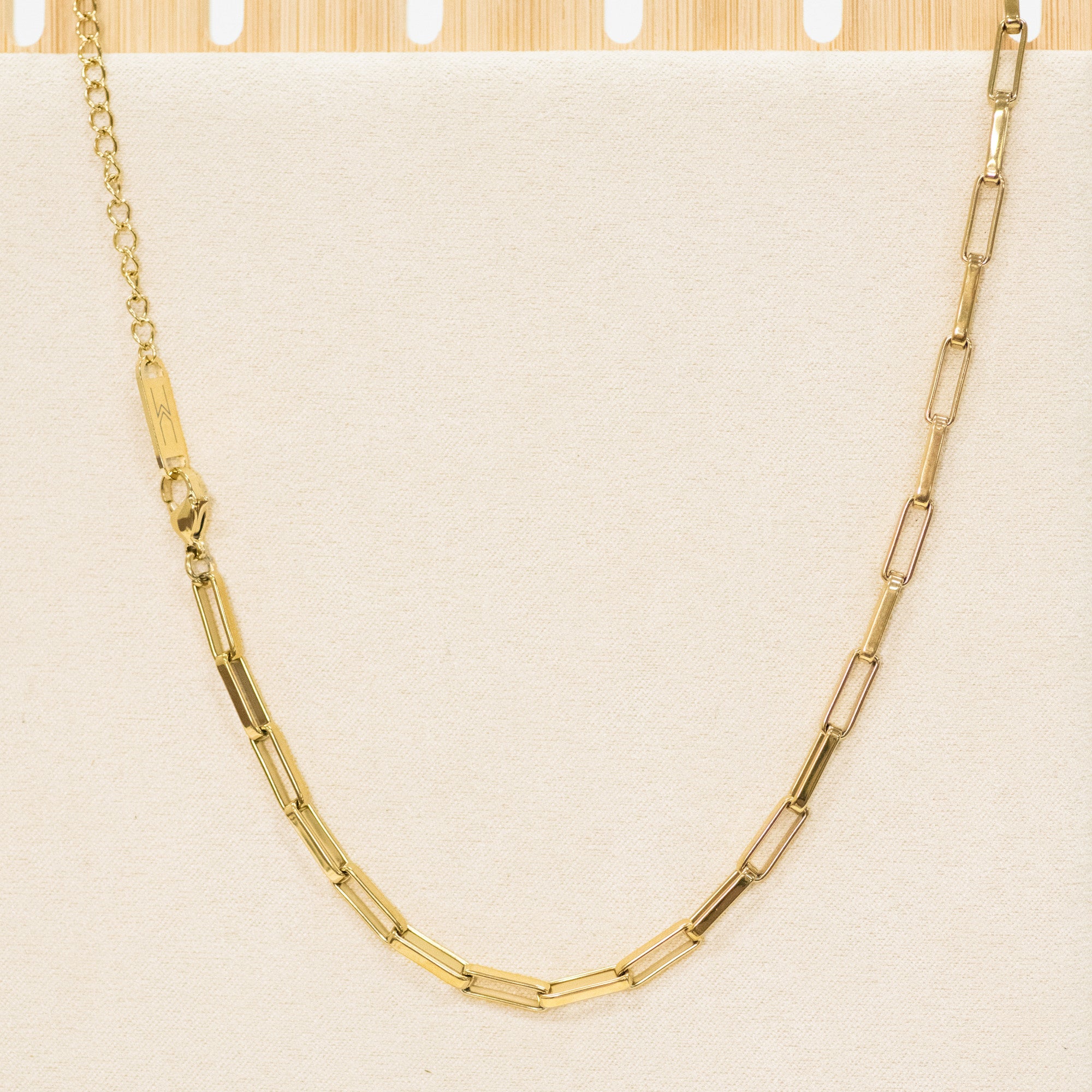 Gold chain necklace on a beige background