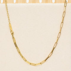 Gold chain necklace on a beige background