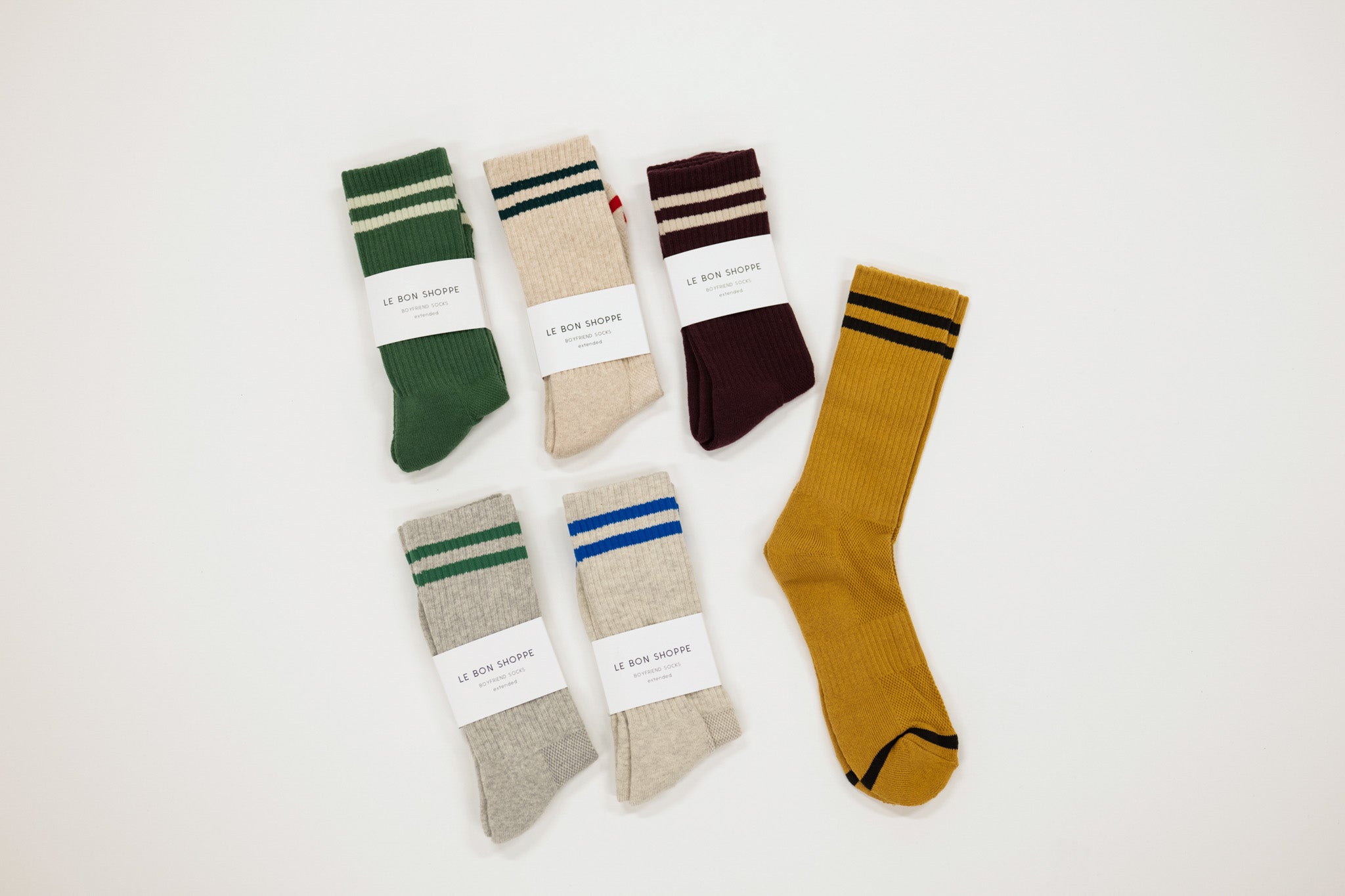 Set of six pairs of socks in various colors with striped patterns on a white background.
