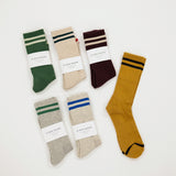 Set of six pairs of socks in various colors with striped patterns on a white background.