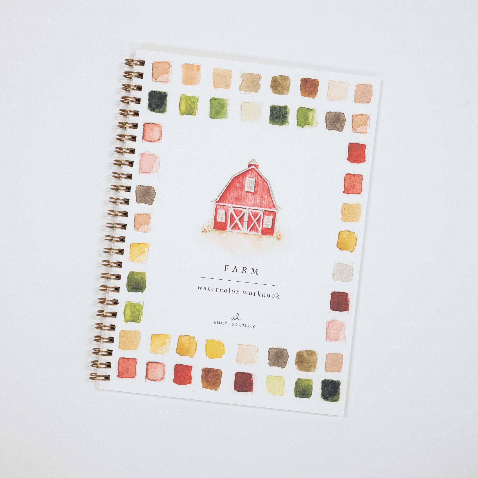 A spiral-bound watercolor workbook titled 'FARM' with a red barn illustration in the center and a border of multicolored watercolor swatches, photographed on a light gray background.