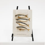 Artistic depiction of fish on a textured surface with a black stand against a white background