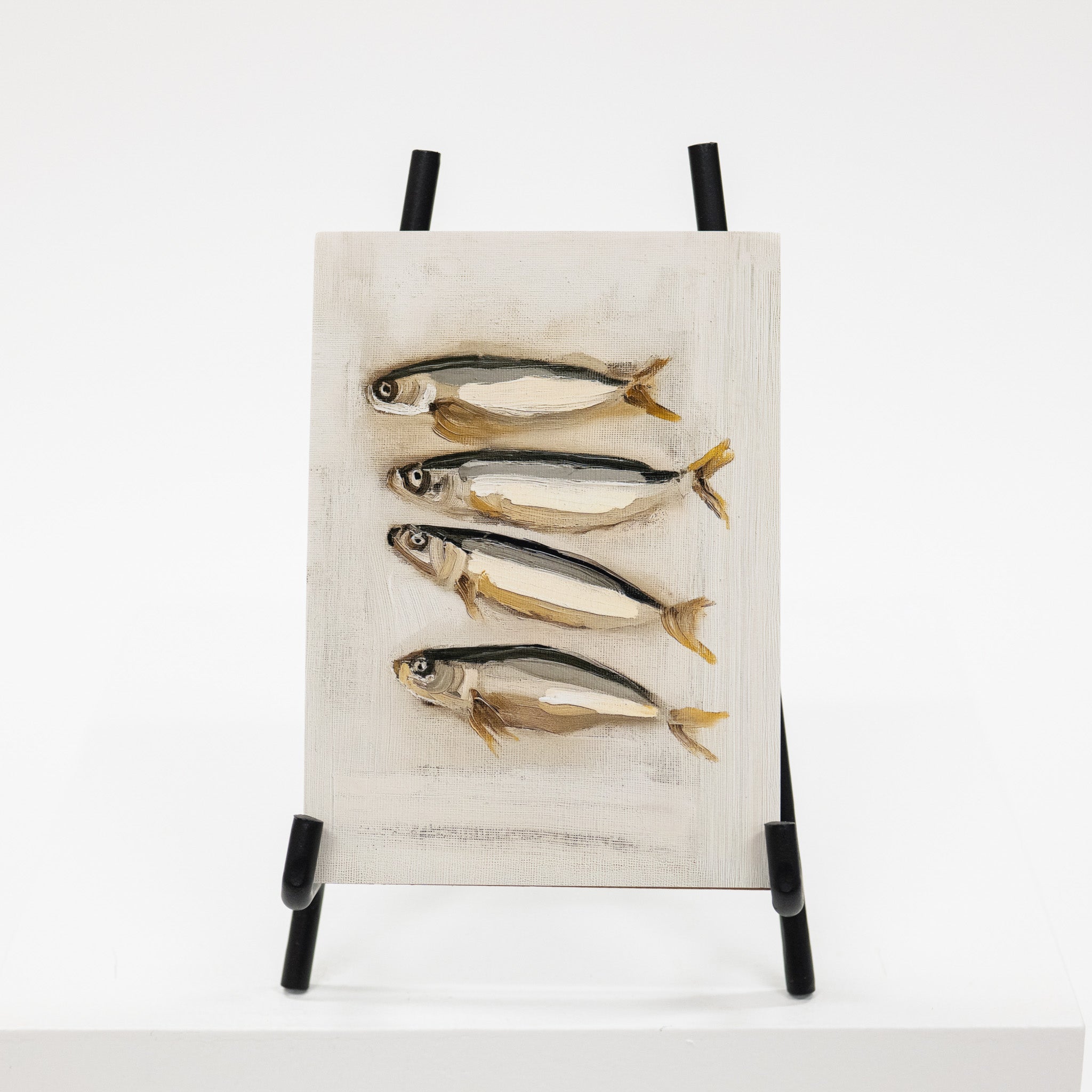 Artistic depiction of fish on a textured surface with a black stand against a white background