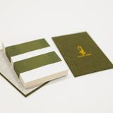 Green flower press with a white cover on a light gray background