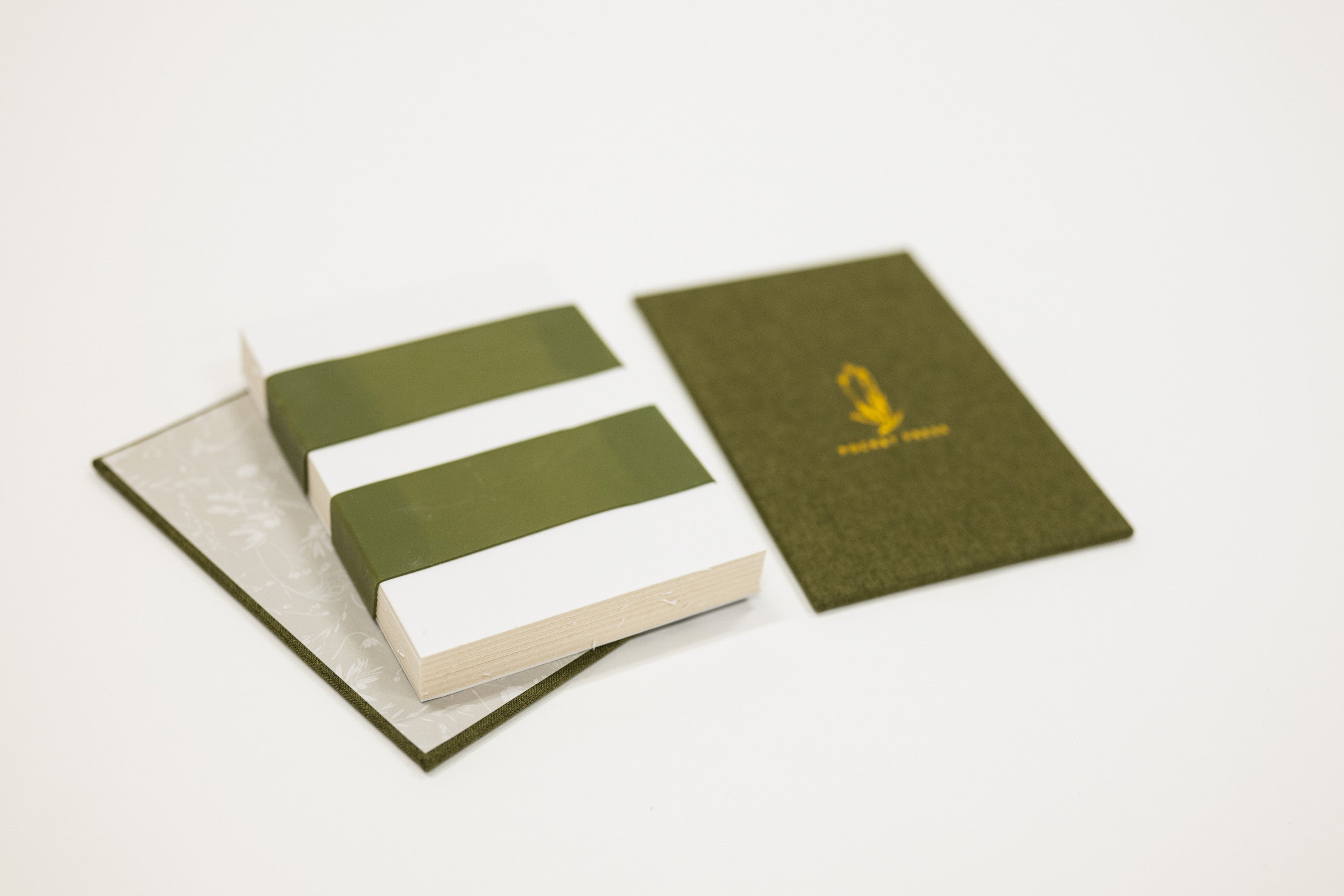 Green flower press with a white cover on a light gray background