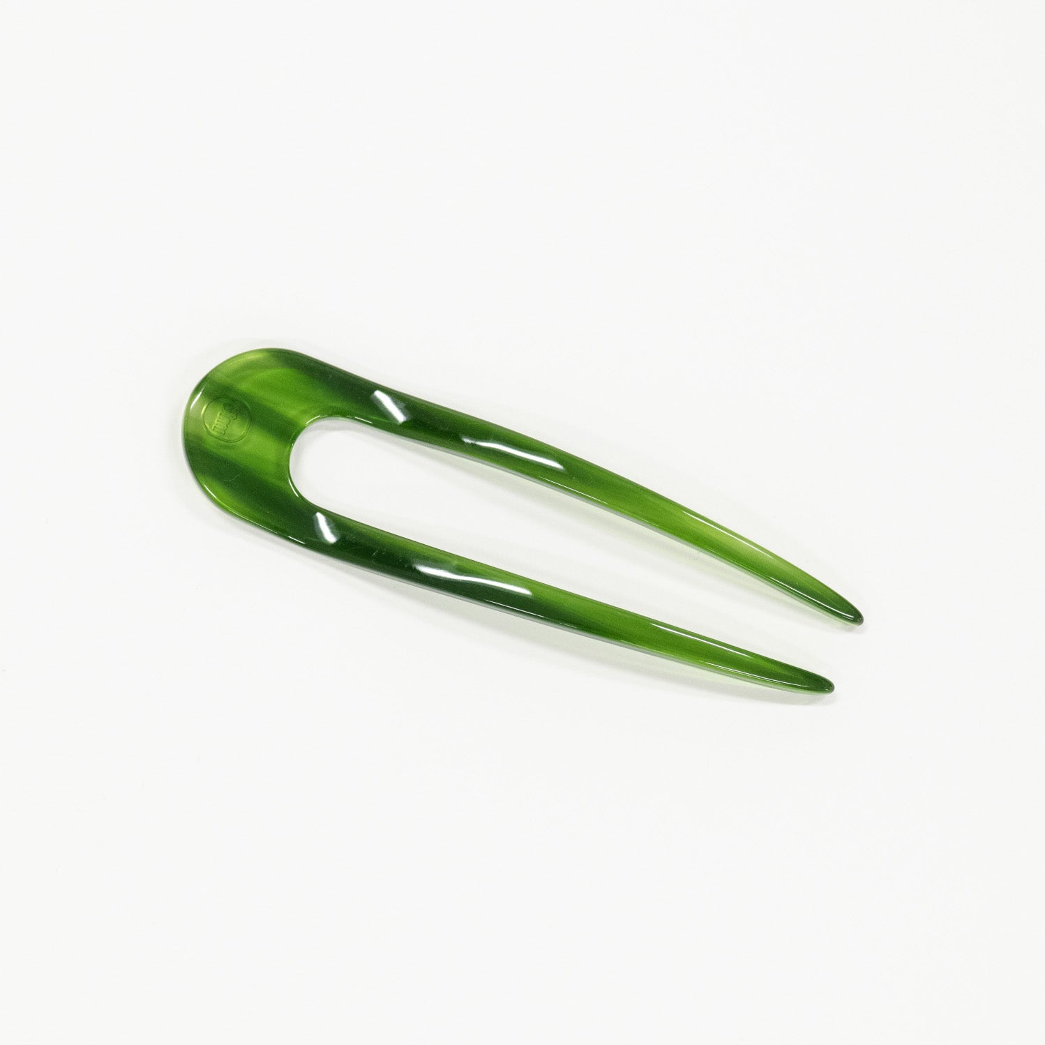 Green hair pin on a white background
