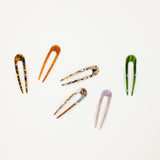 Set of colorful french hair pins on a white background