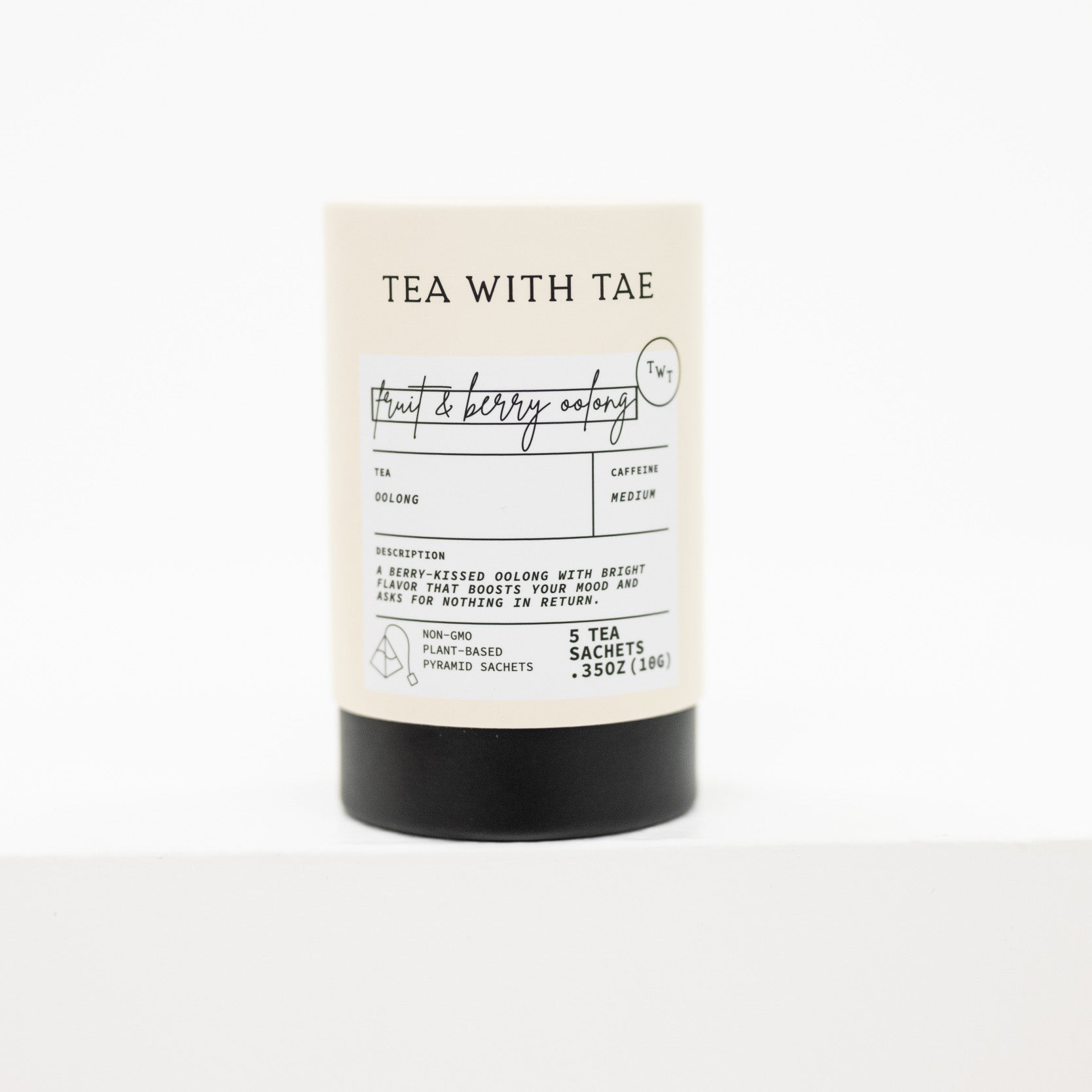 A tea sachet canister with a cream-colored label and a black base, featuring the brand name 'TEA WITH TAE' and the scent 'fruit & berry aromas'.